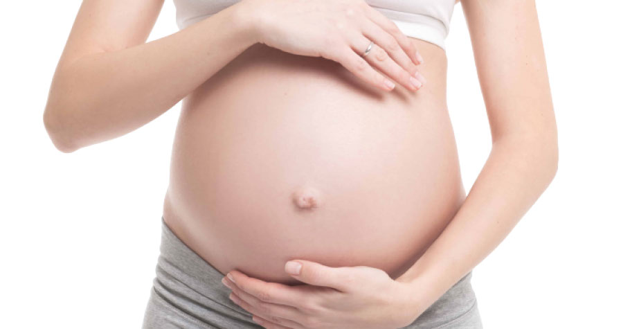 A pregnant belly being cradled by female hands