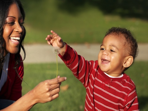 Woman and child playing with a dandelion