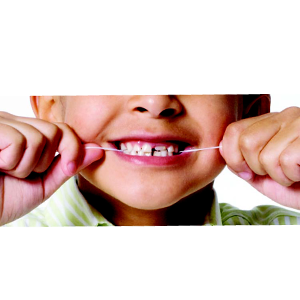 Boca de niño con hilo dental entre los dientes
