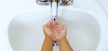 Rinsing hands under water faucet