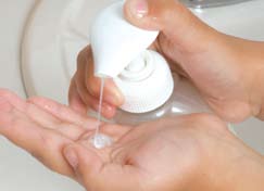 Manos bombeando jabón de manos en las manos