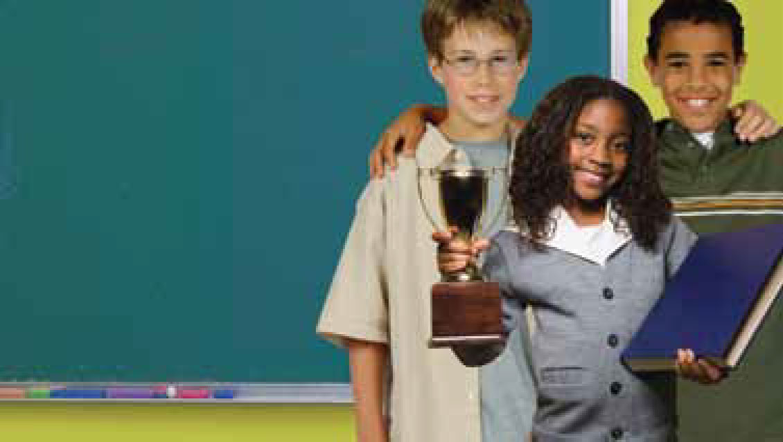 Tres niños de pie juntos sosteniendo un trofeo.