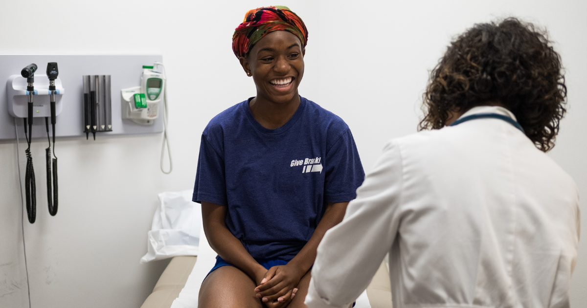 teen health a teen receiving services from doctor and laughing